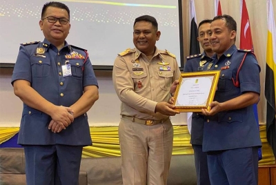 Zainal (kiri) bersama Muhaday (dua dari kiri) menyampaikan pingat kerajaan Thailand kepada pegawai JBPM Kelantan pada Majlis Perhimpunan Bulanan September 2022 di Dewan Utama JBPM Tunjong, Kota Bharu pada Rabu.