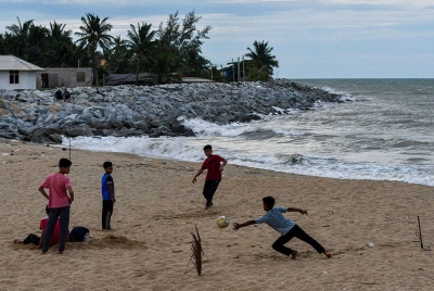 Sekumpulan kanak-kanak memanfaatkan waktu petang dengan bermain bola sepak pantai dalam keadaan cuaca mendung di Pantai Sabak hari ini.