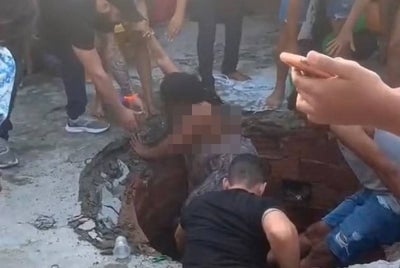 Orang ramai menyelamatkan seorang perempuan yang terjatuh ke dalam lubang di Alagoinhas baru-baru ini. - Foto TikTok