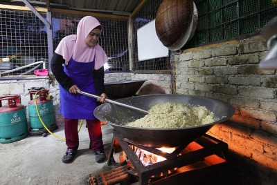 Hafizah menyiapkan sarapan pagi percuma kepada lebih 500 pelajar sekolah dan anak asnaf setiap pagi di flat Projek Perumahan Rakyat (PPR) Lembah Subang. - Foto Bernama