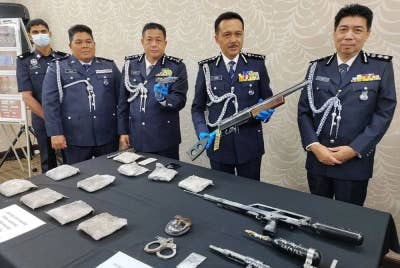 Mohd Yusri (dua dari kanan) menunjukkan senapang angin yang dirampas daripada tukang besi di Sitiawan.