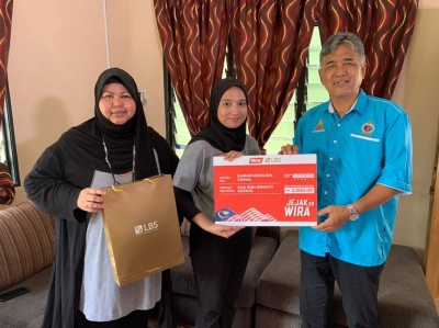 Nur Alia Nadhira (tengah) menyampaikan sumbangan RM2,000 kepada Kamaruddin.