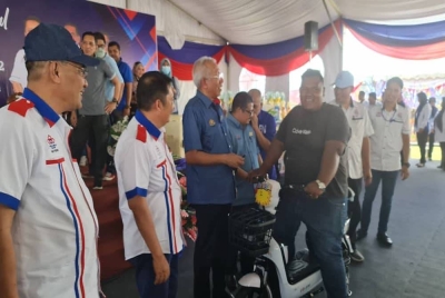 Mahdzir (tiga dari kiri) menyerahkan hadiah kepada pemenang cabutan bertuah sempena Jelajah Mini Karnival Keluarga Malaysia Felcra Berhad 2022 pada Sabtu.