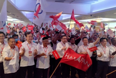 Anthony (empat dari kanan) menyerahkan bendera PH kepada Kor Ming (tiga dari kanan) ketika merasmikan Konvensyen Tahunan DAP Negeri Perak ke-21 di sebuah hotel pada Ahad.