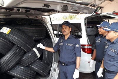 Sazali menunjukkan tayar import untuk kereta mewah yang dirampas daripada dua MPV, selepas sidang akhbar di Menara JKDM Johor, Larkin, pada Ahad.