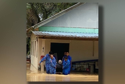 Anggota APM memindahkan mangsa banjir di Pontian ke PPS di SK Melayu Raya, Pontian, pada Ahad, selepas kediaman penduduk dilanda banjir kilat.