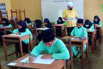 Zulkifli melihat murid-murid menjawab peperiksaan percubaan UPKK.