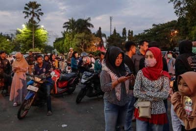 Orang ramai berkumpul bagi memberikan tanda penghormatan kepada mangsa rusuhan bola sepak di Stadium Kanjuruhan di Malang, Jawa Timur pada Isnin. - Foto EPA