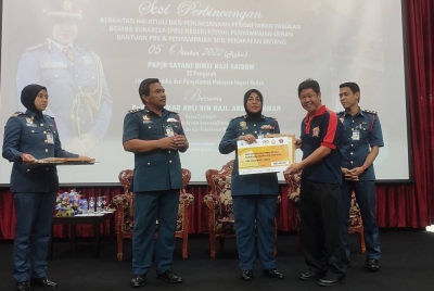Sayani (tengah) menyerahkan geran bantuan kepada wakil PBS Kampung Berjaya pada Majlis Penyerahan Geran Bantuan dan Sijil Penarafan Bintang di Dewan Mohamad Adib Ibu Pejabat JBPM Kedah, Jalan Suka Menanti, Alor Setar pada Rabu.
