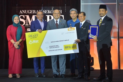 Hamzah (kanan) ketika menerima Anugerah Sekolah S.M.A.R.T Sinar Bestari 2021/2022 kategori Sekolah Rendah Luar Bandar di Hotel Concorde Shah Alam pada Rabu.