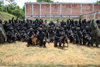 Hishammuddin (tengah) bergambar bersama pasukan BOPKP di Lapang Sasar Menembak Praktikal, Kem Sungai Besi pada Rabu.