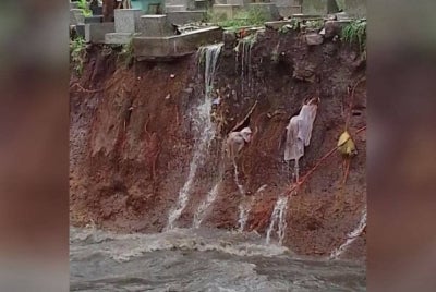 Kain kafan jenazah terjulur keluar akibat hakisan tanah di TPU Sirnaraga, Kota Bandung baru-baru ini. - Foto TXT Dari Bandung