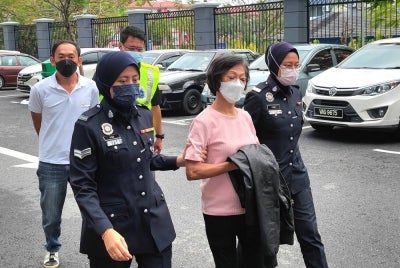 Kedua-dua tertuduh diiring polis ketika tiba di mahkamah.