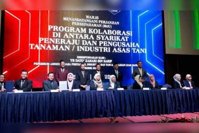 Zahari (tengah, belakang) menyaksikan MoU dalam Program Kolaborasi di Antara Syarikat Peneraju dan Pengusaha Tanaman dan Industri Asas Tani yang diadakan di sebuah hotel di Johor Bahru pada Khamis.