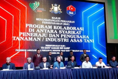 Zahari (tengah belakang) menyaksikan MoU dalam Program Kolaborasi di Antara Syarikat Peneraju dan Pengusaha Tanaman dan Industri Asas Tani yang diadakan di sebuah hotel di Johor Bahru pada Khamis.