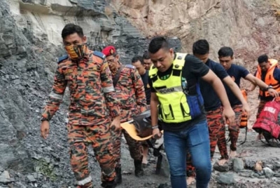Anggota bomba membawa mayat mangsa yang ditemui lemas di sebuah kolam dekat kuari di Bukit Belah, Tikam Batu pada Khamis. Foto JBPM