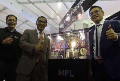 Ahmad Faizal (tengah) dalam sesi fotografi dengan Piala Malaysia bersama Presiden Liga Bola Sepak Malaysia (MFL) Datuk Ab Ghani (kiri) dan Timbalan Menteri Belia dan Sukan Datuk Seri Ti Lian Ker ketika lawatannya ke premis MFL sempena Ekspo Industri Sukan Kuala Lumpur pada Khamis. Foto:Bernama