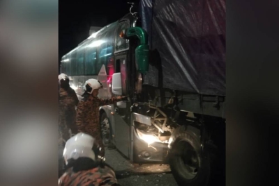 Anggota Balai Bomba dan Penyelamat Meru Raya membantu mengeluarkan pemandu bas yang tersepit akibat kemalangan di KM265 Lebuh Raya Utara Selamat arah selatan awal pagi tadi. - Foto Bomba Perak
