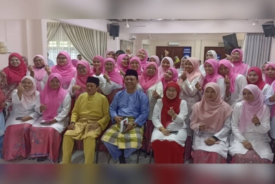 Ahmad (duduk, tiga dari kiri) bergambar bersama Puteri UMNO Bahagian Pontian di Dewan UMNO Pontian pada Jumaat.