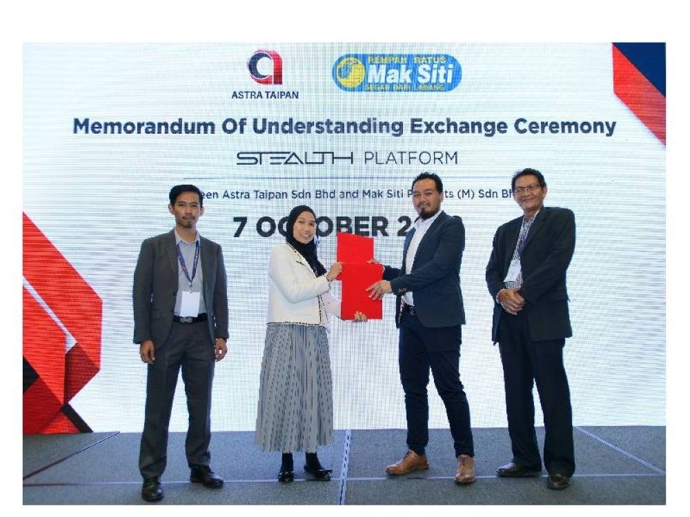 Megat Arif (dua dari kanan) dan Siti Khawa bertukar dokumen perjanjian pada Majlis Pertukaran Perjanjian Persefahaman (MoU) antara Astra Taipan Sdn Bhd dan Mak Siti Products (M) Sdn Bhd sempena Sidang Kemuncak Perniagaan Antarabangsa Selangor (SIBS) 2022 yang berlangsung di Pusat Konvensyen Kuala Lumpur pada Jumaat. Turut bersama Ketua Pegawai Operasi Kumpulan CMAi Capital Group, Amir Awang Hamad (kanan).