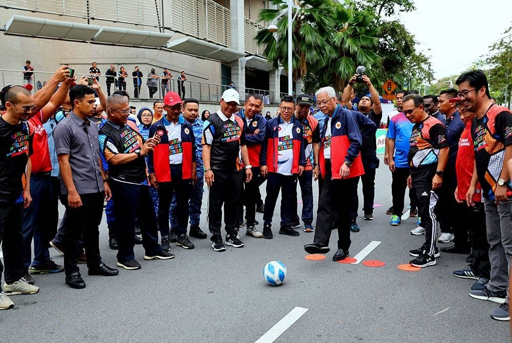 Perdana Menteri Datuk Seri Ismail Sabri Yaakob (tengah) mencuba sepakan penalti sempena Program Hari Sukan Negara 2022 di pekarangan Kementerian Belia dan Sukan (KBS) hari ini.