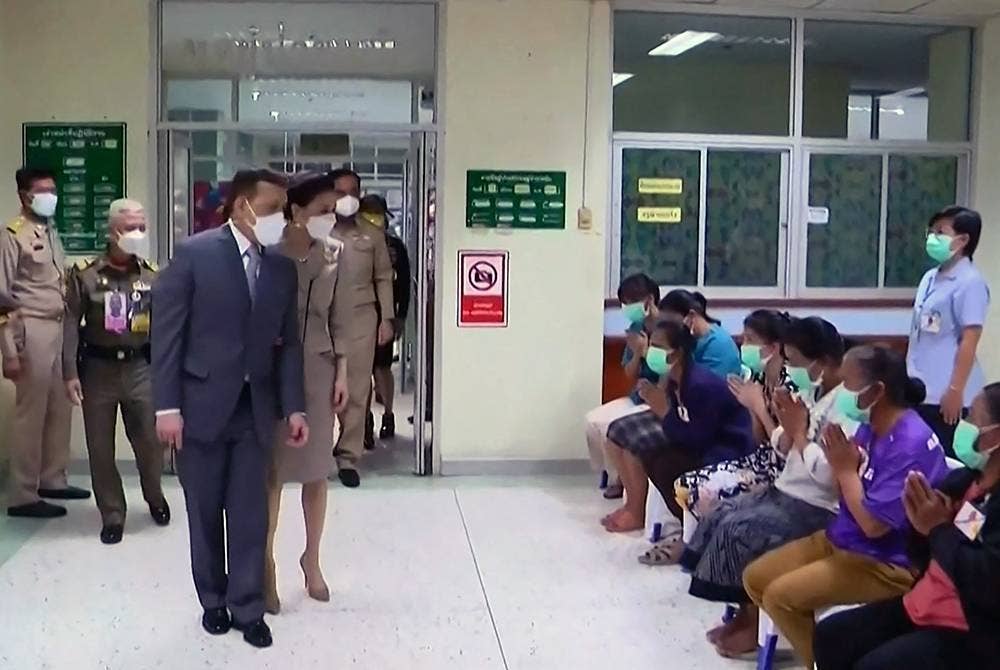 Raja Maha Vajiralongkorn (tiga kiri) diiringi Permaisuri Suthida ketika tiba di sebuah hospital di wilayah Nong Bua Lam Phu. - Foto: AFP
