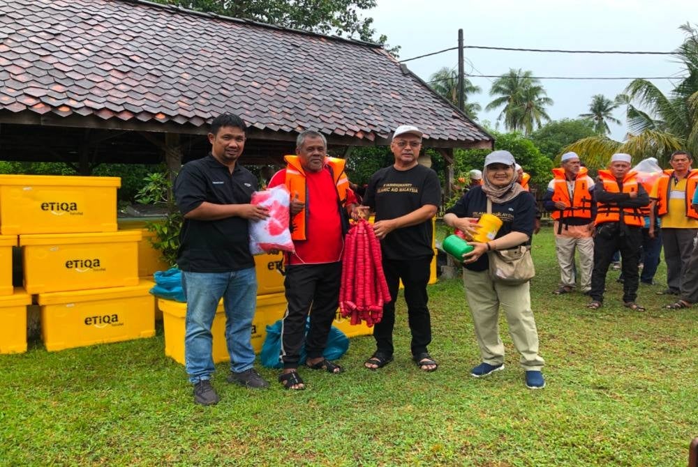 Malik (dua dari kiri) menerima sumbangan pukat daripada IAM yang disampaikan oleh Zawahir (dua dari kanan).