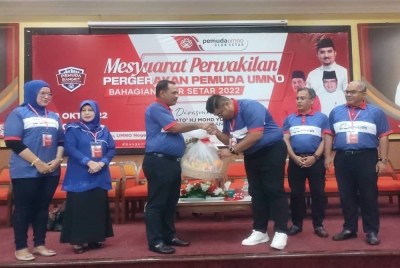 Syed Mohd Johan Rizal (tiga dari kanan) menyerahkan cenderamata kepada Mohd Yusof (tiga dari kiri) pada Mesyuarat Perwakilan Pemuda UMNO Bahagian Alor Setar di Bangunan Tunku UMNO Kedah di sini pada malam Sabtu.