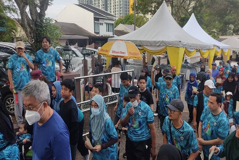 Nasir Khan (kiri) dan Mohd Najwan membuat gimik pelepasan peserta Santai Walk 11 di Madrasah Hidayah Seksyen 11, Shah Alam pada Isnin.