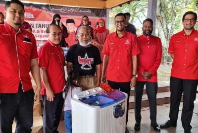 Muhammad Faiz (kiri) dan Fat Full (dua dari kiri) diringi Mahathir (empat dari kiri) ketika menyerahkan sumbangan kepada salah seorang penduduk di Flat Taman Sejahtera, Segambut pada Isnin.