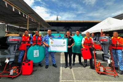 M Ahmad Shazly(empat dari kiri) mewakili Petronas menyampaikan sumbangan kelengkapan banjir kepada agensi penyelamat di Kota Darulnaim, Kota Bharu pada Selasa.