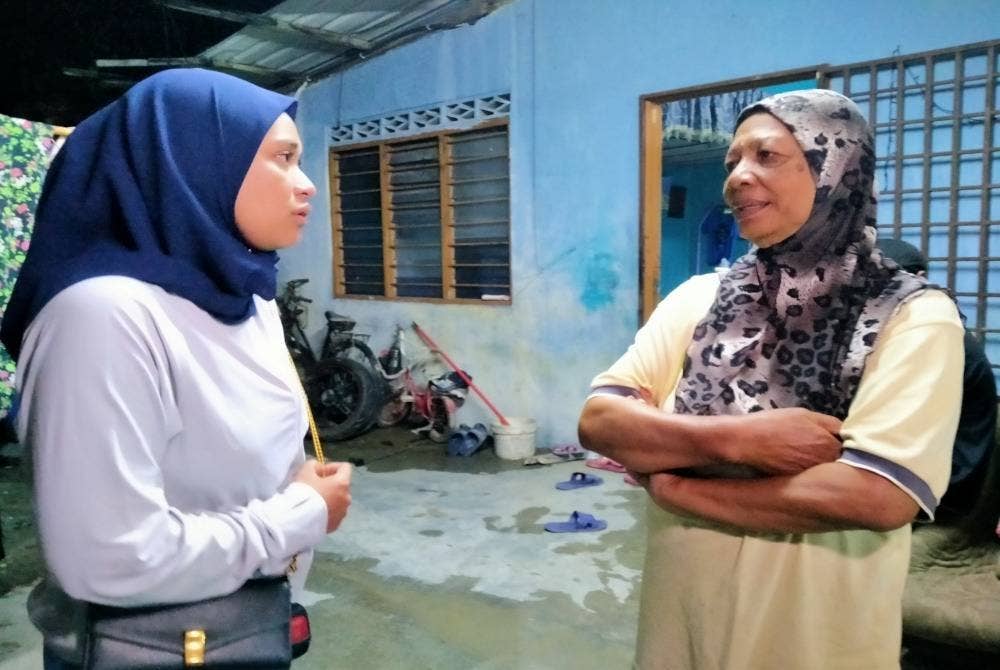 Masdiana (kiri) bertemu dengan seorang mangsa banjir, Suminam Sarmoh, 72, ketika meninjau kerja-kerja menyiapkan lantai dapur rumah mangsa banjir di RPT Chepor di sini pada malam Selasa.