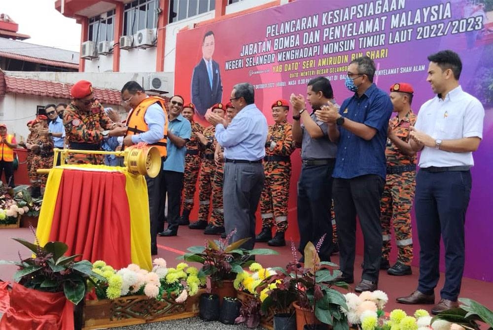 Amirudin dibantu Norazam (kiri) memakai jaket keselamatan pada Majlis Pelancaran Kesiapsiagaan JBPM Negeri Selangor Menghadapi Monsun Timur Laut di Balai Bomba dan Penyelamat Shah Alam pada Rabu.