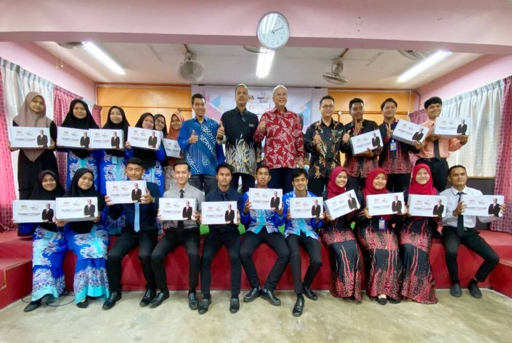 Annuar (lima dari kanan) bersama sebahagian penerima Program Peranti Siswa yang diadakan di SMK Melor, Kota Bharu pada Khamis.