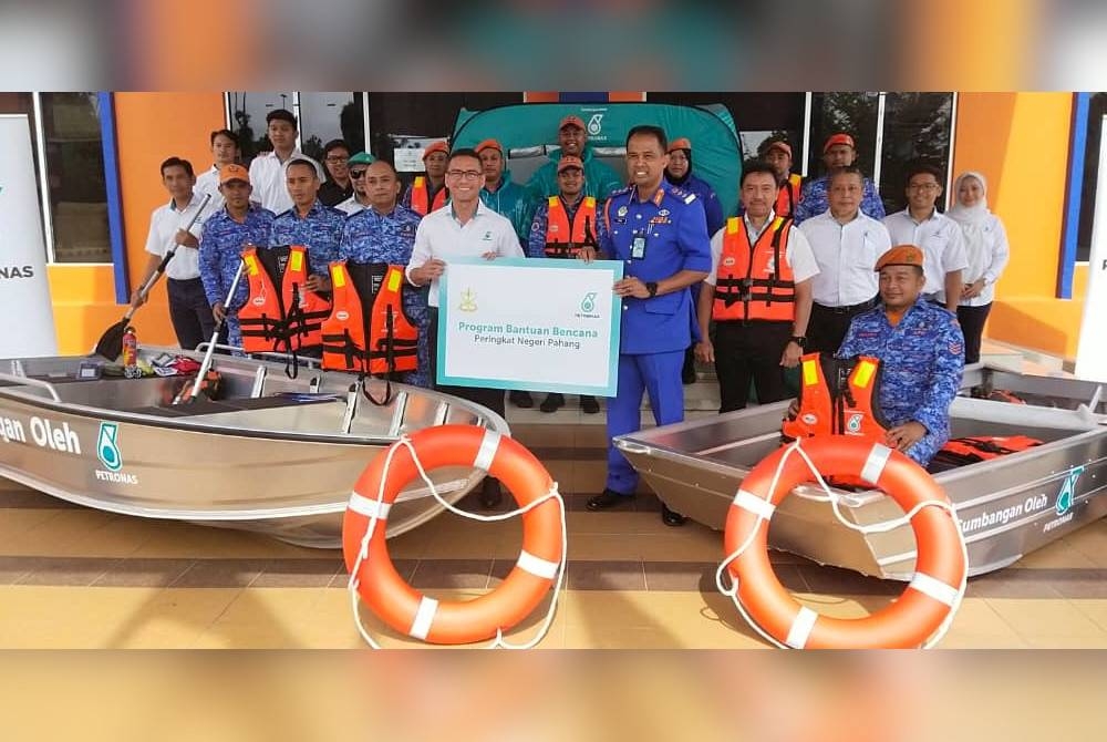 Mohammad Ahmad Shazly (depan,kiri) dan Che Adam bersama antara peralatan persiapan banjir sumbangan Petronas yang diserahkan kepada kerajaan negeri pada Khamis.