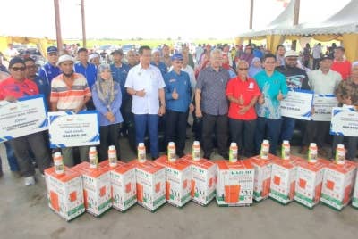 Noh bergambar bersama pegawai dan pesawah yang hadir pada Majlis Perasmian Hari Ladang di Pusat Belian Padi Sungai Burong, pada Khamis.