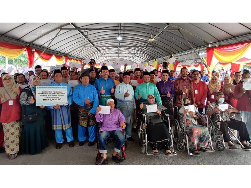 Amirudin bergambar bersama penerima hak milik pada Majlis Penyampaian Surat Kelulusan Hak Milik Tanah Borang 5A Parit 8 1/2 Barat Mukim Sabak di pekarangan Masjid Jamek Sultan Hishamudin di sini pada Jumaat.
