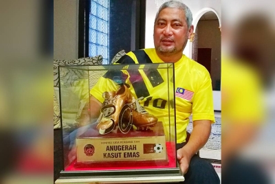 Mohd Hashim menunjukkan anugerah kasut emas yang dimenanginya pada tahun 1993 lalu.