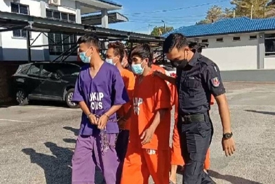 Tertuduh (dua kanan) ketika tiba di pekarangan Mahkamah Kuala Pilah pada Jumaat.