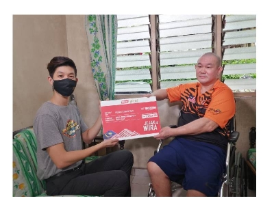 Rayeon (kiri) mewakili LBS menyampaikan sumbangan Jejak Wira bernilai RM2,000 kepada Chein Wai.