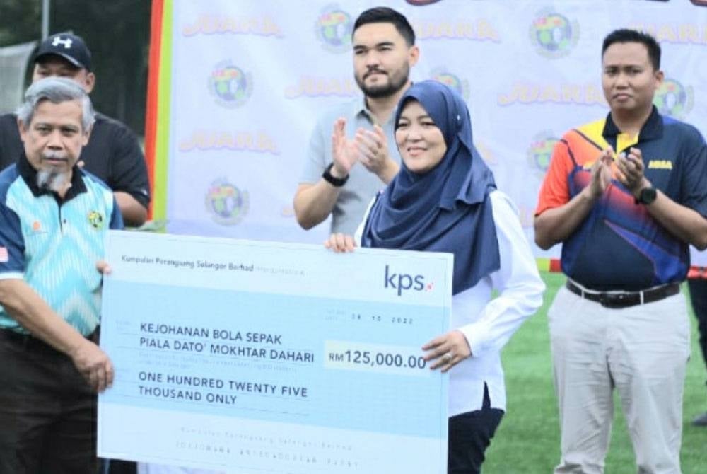 Emran menerima tajaan yang disampaikan Timbalan Ketua Pegawai Eksekutif (Kewangan & Perkhidmatan Korporat) KPS Berhad, Suzila Khairuddin sambil disaksikan Raja Muda Selangor, Tengku Amir Shah Sultan Sharafuddin Idris Shah.