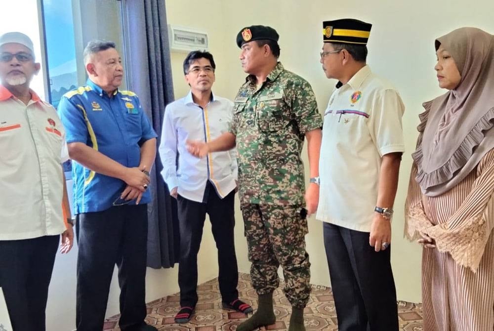 Zambery ( tiga dari kanan) ketika melawat rumah Maznah (kanan).