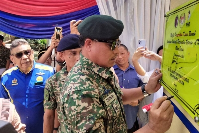 Zambery menandatangani plak rumah yang diterima oleh balu bekas veteran ATM, Allahyarham Mat Resad Salleh iaitu Maznah Mamat, 46.