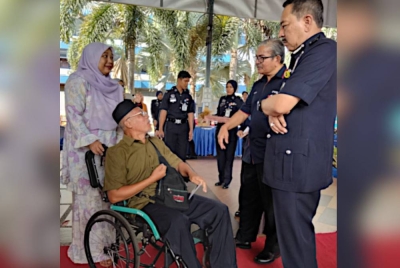 Mazlan (dua dari kanan) diiringi Muhamad Zaki (kanan) menyampaikan sumbangan kepada bekas pesara polis, Rosly Jaaffar, 62.