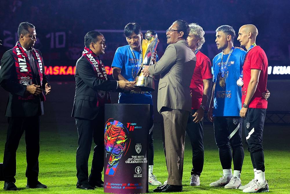 Menteri Besar Johor Datuk Onn Hafiz Ghazi (dua, kiri) menyerahkan Piala Liga Super kepada Ketua Pasukan JDT Mohd Farizal Marlias (tiga, kiri) yang menjuarai Liga Super buat kali kesembilan tahun berturut-turut selepas perlawanan menentang Sabah FC di Stadium Sultan Ibrahim hari ini.  