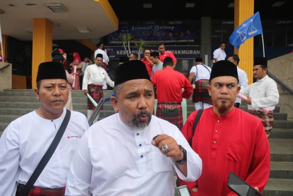 Zool Amali (tengah) pada sidang akhbar selepas mengadakan 'flash mob' sempena Mesyuarat UMNO Bahagian Seremban pada Ahad.