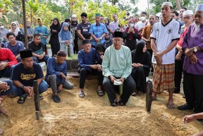 Kamalul Arifin Ahmad (duduk depan tiga, kiri) , 66, bersama ahli keluarga terdekat mendengar bacaan talkin di pusara anaknya, Nurul Nazihah Kamalul Arifin yang maut dalam kemalangan. - Foto Bernama