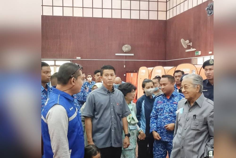 Tun Dr Mahathir (kanan) mendengar penerangan ketika melawat ke PPS Dewan Syifa.