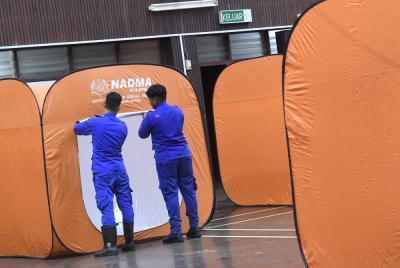 Anggota APM memasang khemah di pusat pemindahan sementara Dewan Syifak di Langkawi yang dibuka untuk pemindahan mangsa banjir pada Ahad. - Foto Bernama