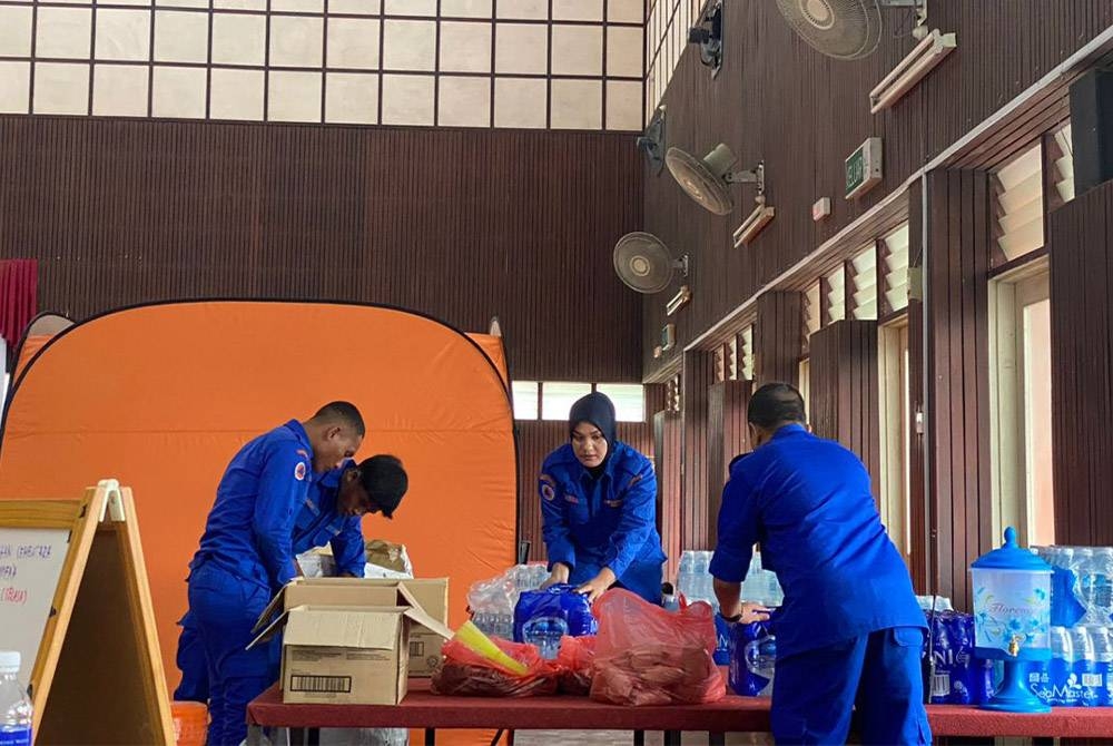 Anggota APM Langkawi menyusun makanan untuk mangsa banjir yang ditempatkan di PPS Dewan Syifa di Padang Matsirat pada Selasa. - Foto APM Kedah